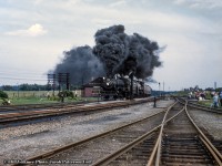 A double-headed excursion behind CPR G5c Pacific 1271 and H1c Royal Hudson 2839 storms past the station at Guelph Junction, cresting the grade beneath a billowing plume of smoke.  The annual NRHS Buffalo Convention was held in Toronto at the end of August 1958 featuring a two-day set of excursions, one over the CPR and one over the CNR the following day. The CPR excursion ran Toronto - Guelph Junction - Hamilton and return via Oakville. The other excursion can be seen at CNR Guelph Junction <a href=http://www.railpictures.ca/?attachment_id=46811>by clicking here.</a><br><br>By this time only four steam locomotives (including the two pictured) were still active out of John Street, 1271 (last G5c Pacific, built by CLC April 1947), Royal Hudson 2839 (H1c, MLW 1937), 1265 (G5c, CLC 1947), and <a href=http://www.railpictures.ca/?attachment_id=40263>2399 (G3g, CLC 1942),</a> all but one of one of which would be retired and scrapped. The survivor, CPR 2839, is now <a href=https://images-wixmp-ed30a86b8c4ca887773594c2.wixmp.com/f/df6d73c0-1cac-4eb5-84b7-888fbe8c781d/ddb2ux2-85c8ef86-6f86-4d66-bfeb-7b519aeb3f62.jpg/v1/fill/w_1920,h_1294,q_75,strp/cpr_h1c_royal_hudson_2839_in_california_1_by_rlkitterman_ddb2ux2-fullview.jpg?token=eyJ0eXAiOiJKV1QiLCJhbGciOiJIUzI1NiJ9.eyJzdWIiOiJ1cm46YXBwOiIsImlzcyI6InVybjphcHA6Iiwib2JqIjpbW3siaGVpZ2h0IjoiPD0xMjk0IiwicGF0aCI6IlwvZlwvZGY2ZDczYzAtMWNhYy00ZWI1LTg0YjctODg4ZmJlOGM3ODFkXC9kZGIydXgyLTg1YzhlZjg2LTZmODYtNGQ2Ni1iZmViLTdiNTE5YWViM2Y2Mi5qcGciLCJ3aWR0aCI6Ijw9MTkyMCJ9XV0sImF1ZCI6WyJ1cm46c2VydmljZTppbWFnZS5vcGVyYXRpb25zIl19.n2-zyXNz7m3i8kOoNznWzZ_m10oS-fBeigMnp8lSkRA>on display at Sylmar California</a> as part of the Nethercutt Collection. Thanks to Ray Kennedy and George Roth for information.<br><br>Standing off to the right, <a href=http://www.railpictures.ca/?attachment_id=44667>Edward P. Haines snapped this shot,</a> while another photographer captured the movement <a href=http://www.railpictures.ca/?attachment_id=47117>crossing over to the Oakville Subdivision</a> at Hamilton Junction.<br><br><i>Bill Volkmer Photo, Jacob Patterson Collection slide.</a>