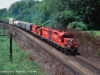 A trio of CP GP9u's (CP 8222, CP 8225, and CP 8205) executing running rights across CN's Oakville sub with an eastbound freight in August of 1992