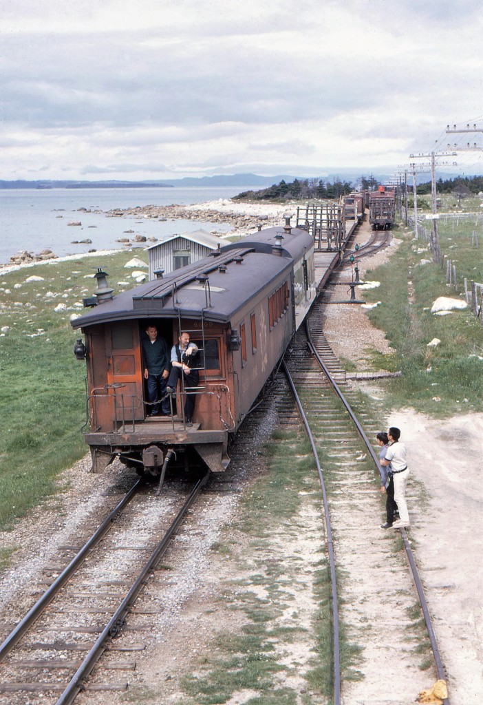 KEEPING AN EYE IN KELLIGREWS - Travelling with four University of Toronto friends - including the late James A. Brown - to celebrate Canada's Centennial by riding Newfoundland's endangered passenger train 'Caribou', John Freyseng of Ontario was able to capture some amazing narrow gauge images. Here he photographs a rearward view of CN Train No. 208, the Carbonear Mixed, departing Kelligrews for St. John's while westbound freight CN No. 401 waits on the siding in the background on June 22, 1967. His unique vantage point was accessed by climbing on top of a boxcar with his friend Jim who while standing alongside him, captured pretty much an identical image. John and Jim's eye for the human element emphasized the conductor and rear brakeman keeping watch on the two observers with the younger being protected by the older as the train passes by. Caboose 6009 was originally built as second class coach 114 in 1902 for the Newfoundland Railway and later converted for both crew and passengers for branchline service. The community of Kelligrews was made famous in the Newfoundland folk song 'Kelligrews Soiree' by balladeer Johnny Burke in 1904 and recorded by dozens since then. More of 1967 John Freyseng photos can be seen in my upcoming TRAINS OF NEWFOUNDLAND, to be released by Flanker Press in both hard and softcover editions on September 9, 2022.