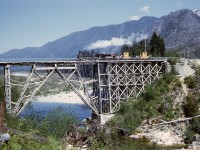 Precisely fifty-one years ago today, on Saturday June 5th 1971, Canadian Forest Products operated their ALCo 2-8-2 locomotive 113 on passenger excursions on Vancouver Island in the Nimpkish Valley from Woss Camp to Woss Lake and return, in conjunction with a Loggers’ Sports Day.  Just west of operating headquarters at Woss Camp, a combination rail-and-road bridge crossed the Nimpkish River, seen here with 113 and two caboose cars westbound two miles to Woss Lake.

<p>This was quite early (only 18 years old) in my railway photography journey, and taken with a borrowed Voightlander rangefinder camera.  To this day I remain surprised at how well it came out, my very first good train action photo.