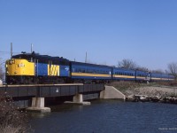  The sign on the bridge reads 4mph for boat traffic but the speedometer on VIA 6783 is probably pushing 85mph as No 171 sails through Belle River over its namesake river on a Nov 9th 1986 morning.   