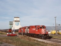 On the Lacombe sub. in central Alberta, an eastward Coronation Turn with a pair of GP38-2s, 3056+3130, is returning to their train of empty grain hoppers after spotting empties on the elevator track.  Nowadays the rails only reach 15 miles farther east to Botha.