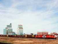 On the CP Lacombe sub. in central Alberta, a Coronation Turn with a pair of GP38-2s, 3056+3130, is eastward at 1117 MDT on Sunday 1991-10-06 with twelve empty grain hoppers through the village of Halkirk at mileage 33.7.  Nowadays the rails only reach 15 miles to the west at Botha.

<p>Yes, this is the same train as posted last week, that one originally marked as at Halkirk but with the wrong photo, and actually at Stettler, as first noted by SD70Dude.  Thanks to Steve Host for straightening that entry out for me.