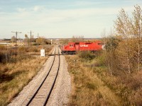 On the north side of the town of Stettler in central Alberta, the CP Lacombe sub. at mileage 56.5 (westward from Coronation) crossed the Central Western Railway at Stettler sub. mileage 50.4 (measured southward from Ferlow Jct. near Camrose).  In this northward view on CWR, a CP Coronation Turn is westbound on Sunday 1991-10-06 at 1635 MDT, heading for home at Lacombe.  Visible beyond the signal in the distance is the interchange connection from CWR to CP — this is now all Alberta Prairie Railway Excursions territory.