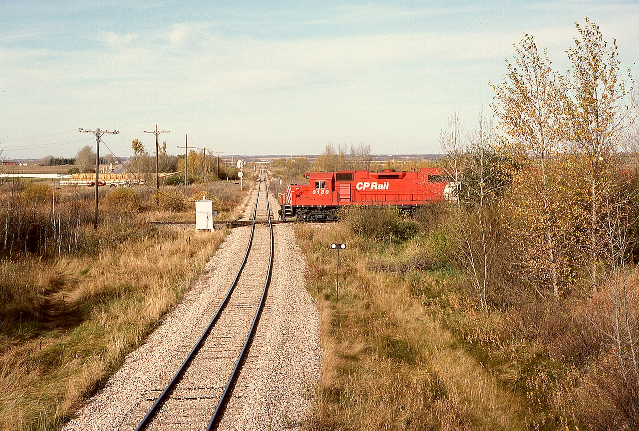 On the north side of the town of Stettler in central Alberta, the CP Lacombe sub. at mileage 56.5 (westward from Coronation) crossed the Central Western Railway at Stettler sub. mileage 50.4 (measured southward from Ferlow Jct. near Camrose).  In this northward view on CWR, a CP Coronation Turn is westbound on Sunday 1991-10-06 at 1635 MDT, heading for home at Lacombe.  Visible beyond the signal in the distance is the interchange connection from CWR to CP — this is now all Alberta Prairie Railway Excursions territory.