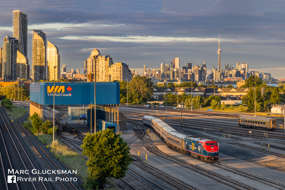 Welcome Back To Canada. For the first time since 2020, the Amtrak Maple Leaf (Train 63/VIA Train 98) returned to Toronto, Ontario on Monday, June 27, 2022. Due to a suspension related to the pandemic, service on the Maple Leaf had been operating between only between New York’s Penn Station and Niagara Falls, New York. For the occasion, Amtrak 108 (P42DC, 50th Anniversary, Phase VI) was selected to lead the first run. The train is seen at the end of the day with the CN Tower emerging from the Toronto, Ontario skyline, entering the VIA Toronto Maintenance Centre where it will spend the night before returning as Amtrak Train 64/VIA 97 the following morning.

More on Amtrak's Commemorative 50th Anniversary Locomotives: https://media.amtrak.com/2021/03/amtrak-releasing-six-50th-anniversary-commemorative-painted-locomotives/