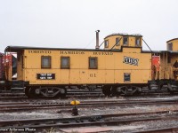 <b>”Tight Grip, Safe Trip”.</b>  One of TH&B’s safety slogans adorns the side of van 61 at Aberdeen Yard.  61 has been preserved in a few different forms over the years, originally as <a href=http://www.railpictures.ca/?attachment_id=39637>Port Stanley Terminal Rail 61,</a> later to <a href=http://www.trainweb.org/oldtimetrains/tourist/STCR_61.jpg>St. Thomas Central 61,</a> and finally to the Waterloo Central where it resides today, recently <a href=https://waterloocentralrailway.com/wp-content/uploads/2021/05/gjm-258491.jpg>restored to full TH&B appearance.</a>  Van 63 can be seen at right.