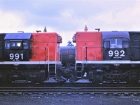 Just passing through!!!  CN's two G-12s, 991 and 992, are shown in Capreol, Ontario on their way west to their new home on Vancouver Island.  The units were built for the London and Port Stanley Railroad in 1955 and 1957.  991 ex L&PS L4 built 8/1955 b/n A832 (some sources show the b/n as A831) and 992 ex L&PS L5 built 7/1957 b/n A1324.  Both units acquired by CN on January 1,1966 and retired in 1976 and scrapped. Of note are the different trucks and cabs on the units.                