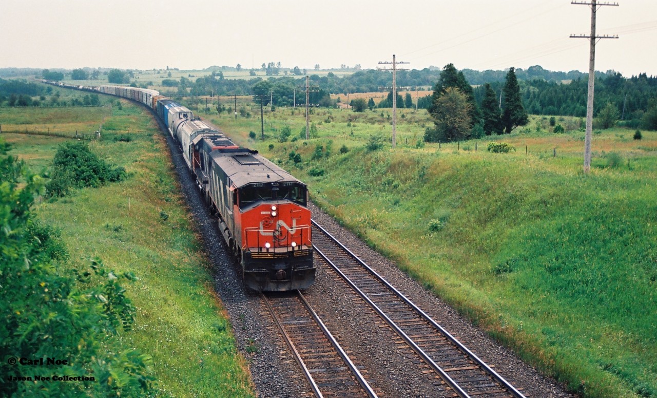 Back in the day, the Newtonville, Ontario area was always considered one of the most coveted railfan locations, situated east of Toronto where both CP and CN mainlines paralleled each other for miles. On our initial trip there, the first train we photographed didn’t disappoint as well as the scenery of the area. Here CN HR616 2117 and an SD40 are seen leading a westbound train through the sweeping curve at Newtonville on July 15, 1994. CN 2117 would be retired three years later in 1997 and the all the remaining active HR616’s were retired during 1998.