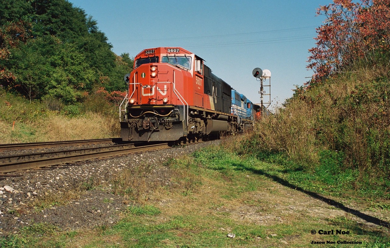 CN 385 is just west of Dundas, Ontario viewed at Mile 7 on the Dundas Subdivision as it slowly approaches the Middletown Road overpass with 5607, GATX 3702 and 9665 during a fall afternoon.