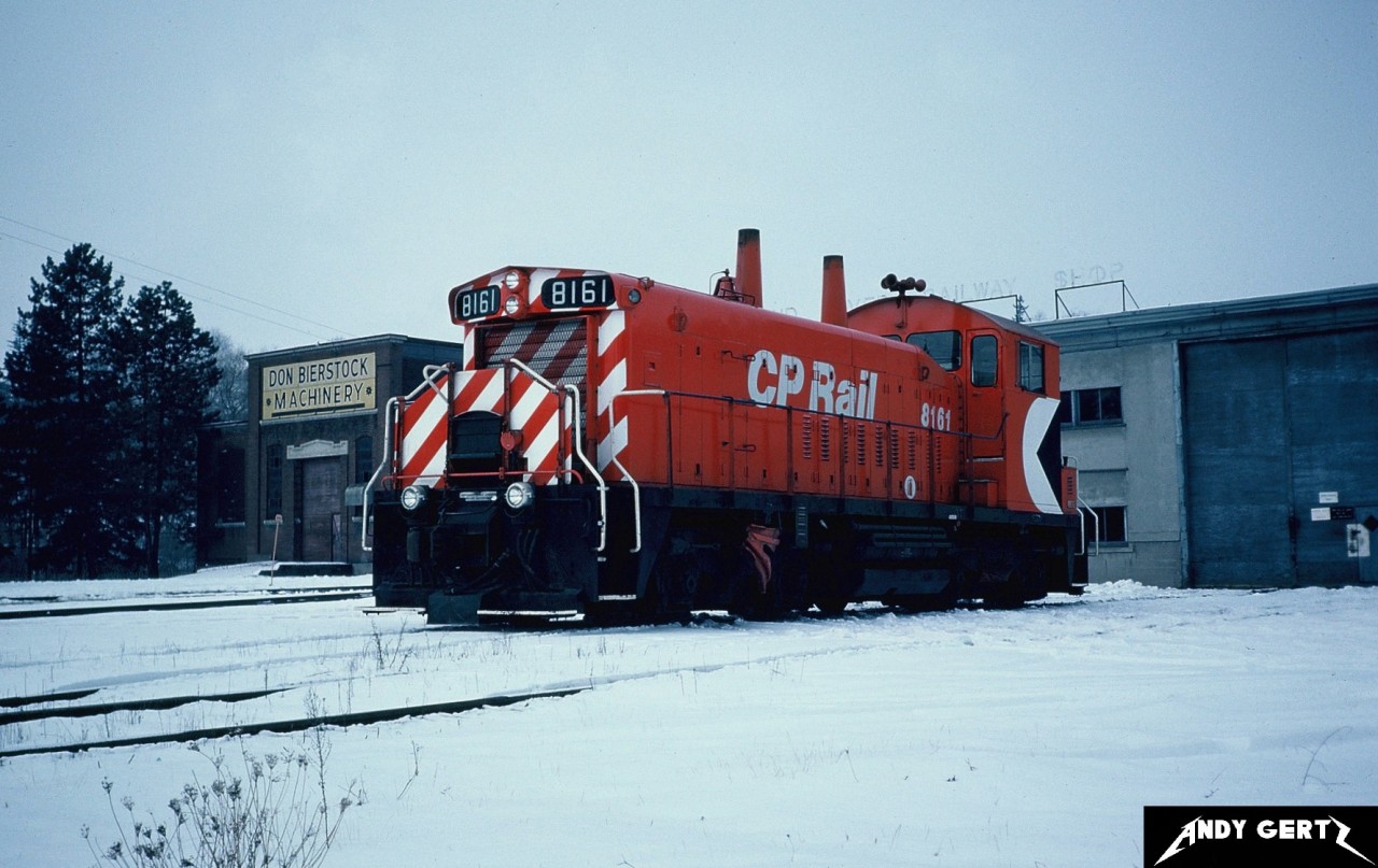 CP SW1200RS 8161 sits in front of the old Grand River Railway shop along King Street in the Cambridge suburb of Preston, Ontario during winter 1982.