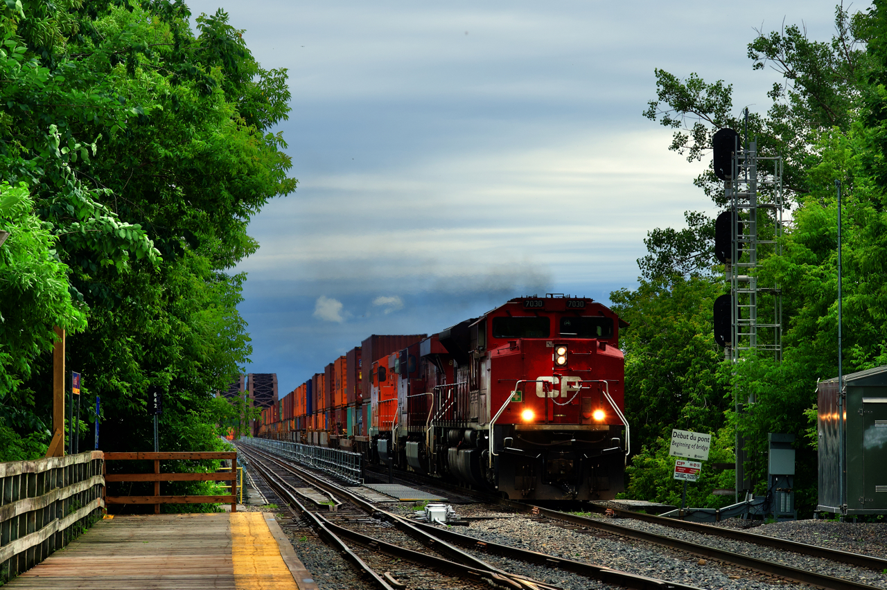 When I first heard rumours that CP was planning to buy the CMQ and retake their line towards Saint John, New Brunswick, I dismissed it as something that would never happen. Why would CP want a line that only generated enough traffic for one through freight each way per day? Well, seeing a 100% intermodal CP 223 crossing the St. Lawrence River (with 137 platforms per an OS) was impressive and shows that it seems to have been a very worthwhile purchase for CP, with business booming (intermodal in particular). It sounds like soon there will be both an intermodal and a manifest pair of trains, once CP has enough crews. In the meantime, CP is running DPUed trains and having to leave traffic behind.

Power on this CP 223 is CP 7030, CP 8806 & CP 8781 and the train is about to pass Lasalle Station