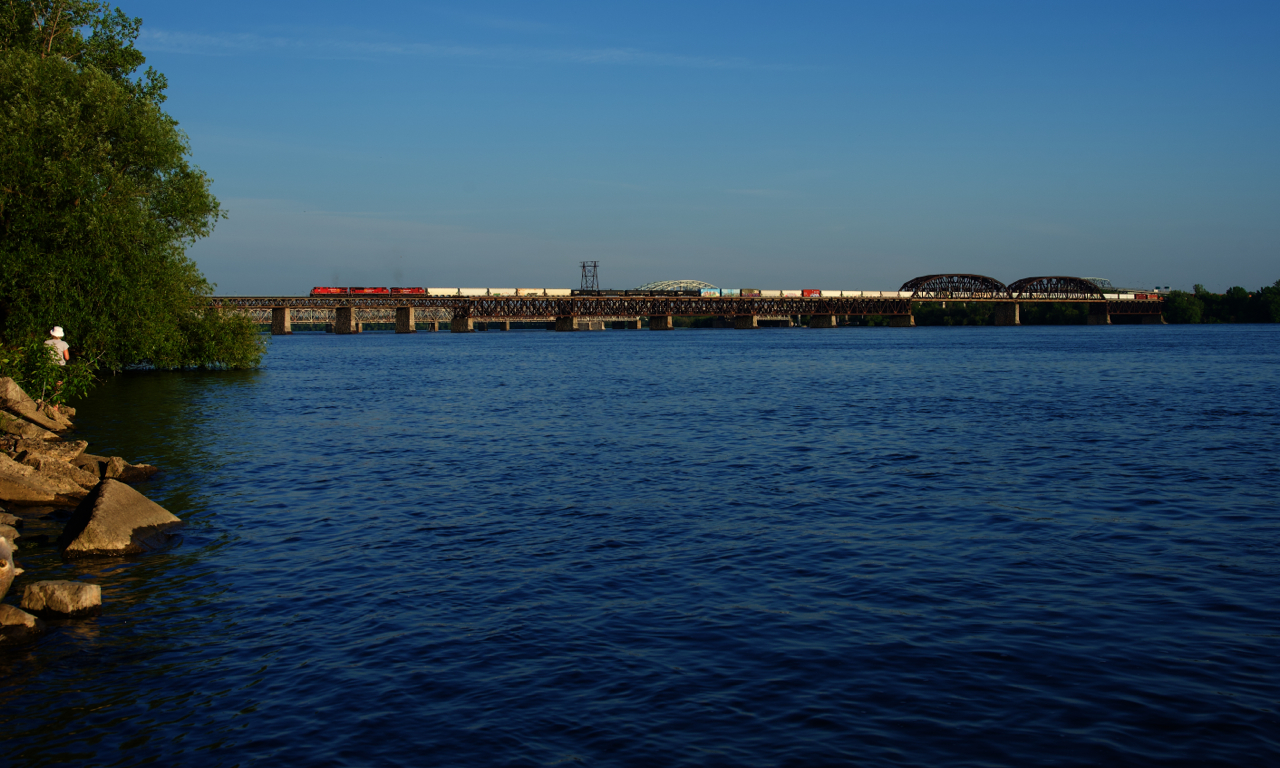 CP 223 crosses the wide St. Lawrence River on one of the longest days of the year.