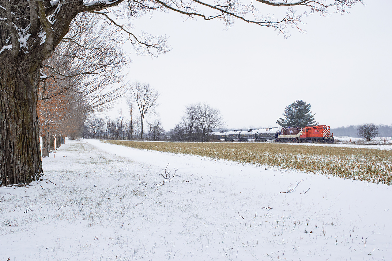 A light dusting of snow is in the air as the St. Thomas job cuts across the open fields just east of Putnam with a pair of GP9s running long hood forward. Having a few hours of free time, I had been headed to St. Thomas after getting word LDSX 1597 had been dropped overnight for GIO Rail's new operation on the Cayuga Sub, and figured as long as I'm in the area, may as well take advantage of a short chase on the OSR. Shortly however, I would break off my chase near Mossley once I got word the Cayuga was alive with the first train to Tilsonburg south since April 2020.
