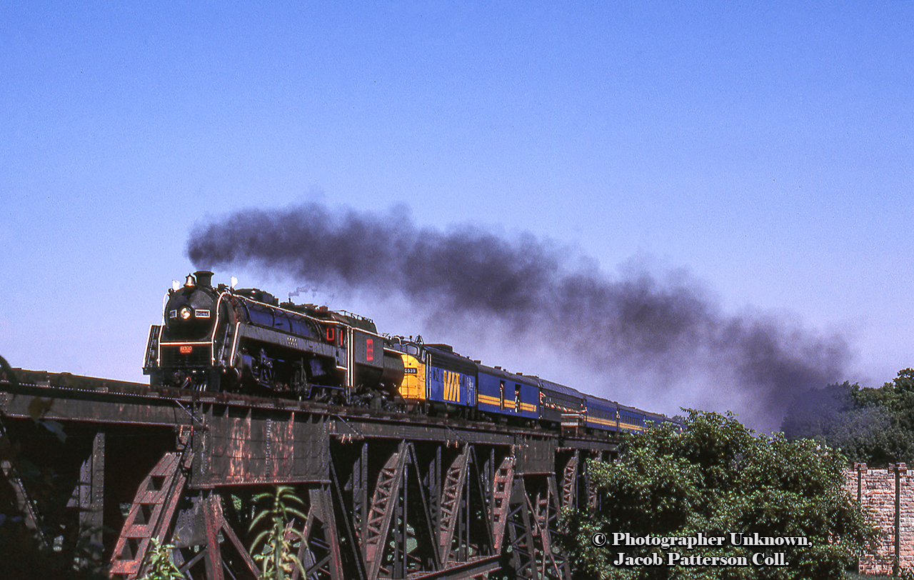 A different take on the bridge at Jordan, CNR 6060 makes it’s return trip from Niagara Falls to Toronto with it’s second last excursion run in Ontario, running under the banner of the “Maple Leaf” in homage to the joint Lehigh Valley/Canadian National train discontinued in 1961.Two days later, Saturday, July 26 would be 6060’s final run in Ontario with the “Canadian Crusader” special doing a loop around Lake Simcoe, north on the Bala to Washago, and back south via the Newmarket.   A week later, on Saturday, August 2, 6060 would be on train 375 departing Toronto for Edmonton, arriving on Friday, April 8.  It would make the cross-country journey under steam to keep it’s lubricator operational.More from this day:Niagara-bound at BayviewWestbound through MerritonA closeup at BayviewThe special arriving back at Toronto Original Photographer Unknown, Jacob Patterson Collection Slide.