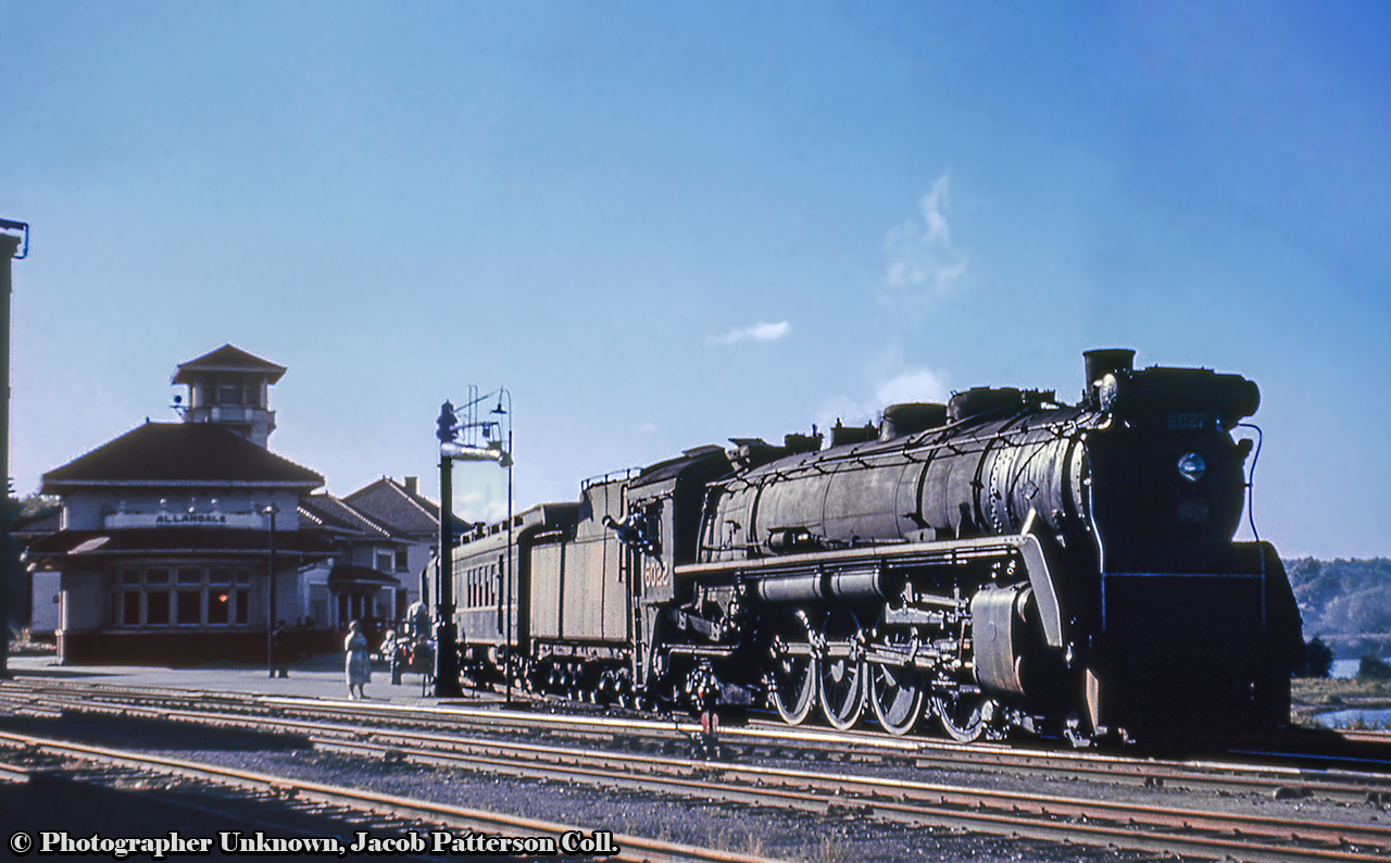 CNR U-1-b 6022 pauses at Allandale with daily except Sunday, North Bay to Toronto train 44.  Arriving at 1624h, the train will hold for 16 minutes, departing at 1640, with final arrival at Union Station at 1910h.  Note the engine crew leaning out of the cab, the RPO car first up, and the baggage cart just left of the stand pipe.Original Photographer Unknown, Jacob Patterson Collection Slide.