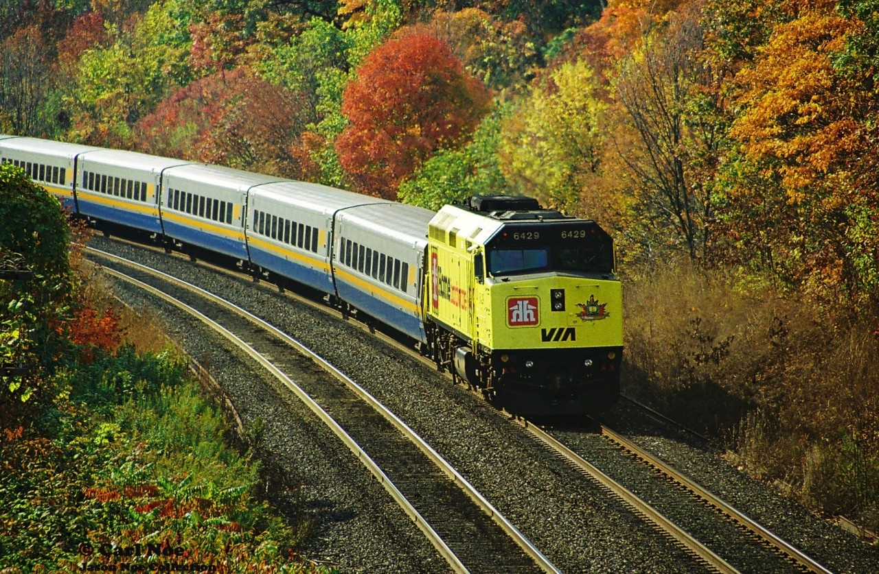VIA Rail F40PH-2 6429, adorned in its Home Hardware wrap is viewed trailing on #73 with 6413 leading westbound, seen from the former Snake Road walk bridge (now named Beth Jacob Court) on the Oakville Subdivision, just east of Bayview Junction.