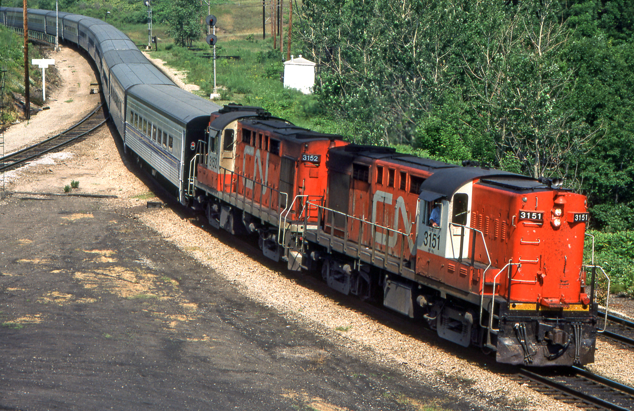 An eastbound VIA Tempo train headed by CN 3151 is entering a super-elevated curve in Hamilton, Ontario in June 1981.