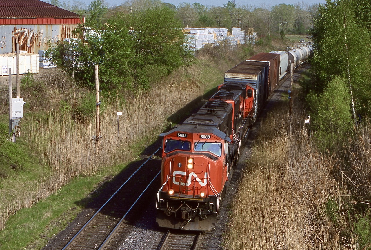 CN train 338 is seen departing Clifton / Niagara Falls. The train is passing the long gone lumber yard at mile 3 that was back then a regular rail served customer. Today it is a landscape supply yard with no need for rail service.