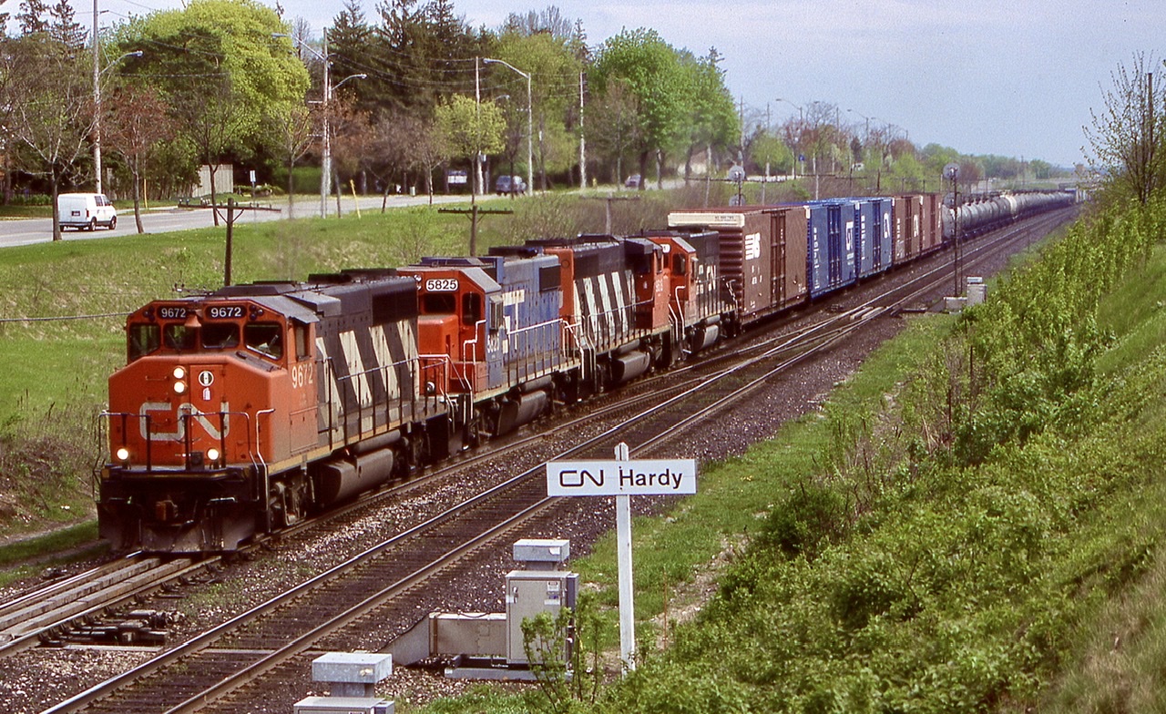 I always had a liking for CN’s wide cab GP40’s especially the ex GO Transit ones. Here one leads a westbound with a nice mix of power including a GTW GP38, another CN GP40 and CN/GTW GP40 6401 in “Operation Lifesaver” paint. I believe 6405 was the only other GP40 to wear this paint. There were other GTW painted units that also received “OL” paint. The train is just getting on the move again after stopping for about 45 minutes to fix a bad hose bag. I always loved this angle and hillside shots at Hardy and regret not taking them more often as this location today is very overgrown. The trailing cut off tank cars will be dropped at Paris for Railink to forward to Nanticoke.