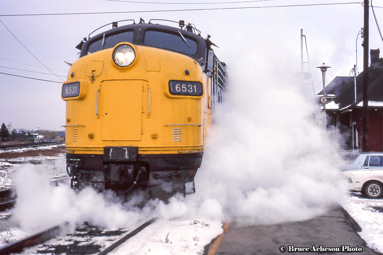 Steam spills into the cold air from beneath FP9A 6531 as it pauses at Burlington West with train 73.