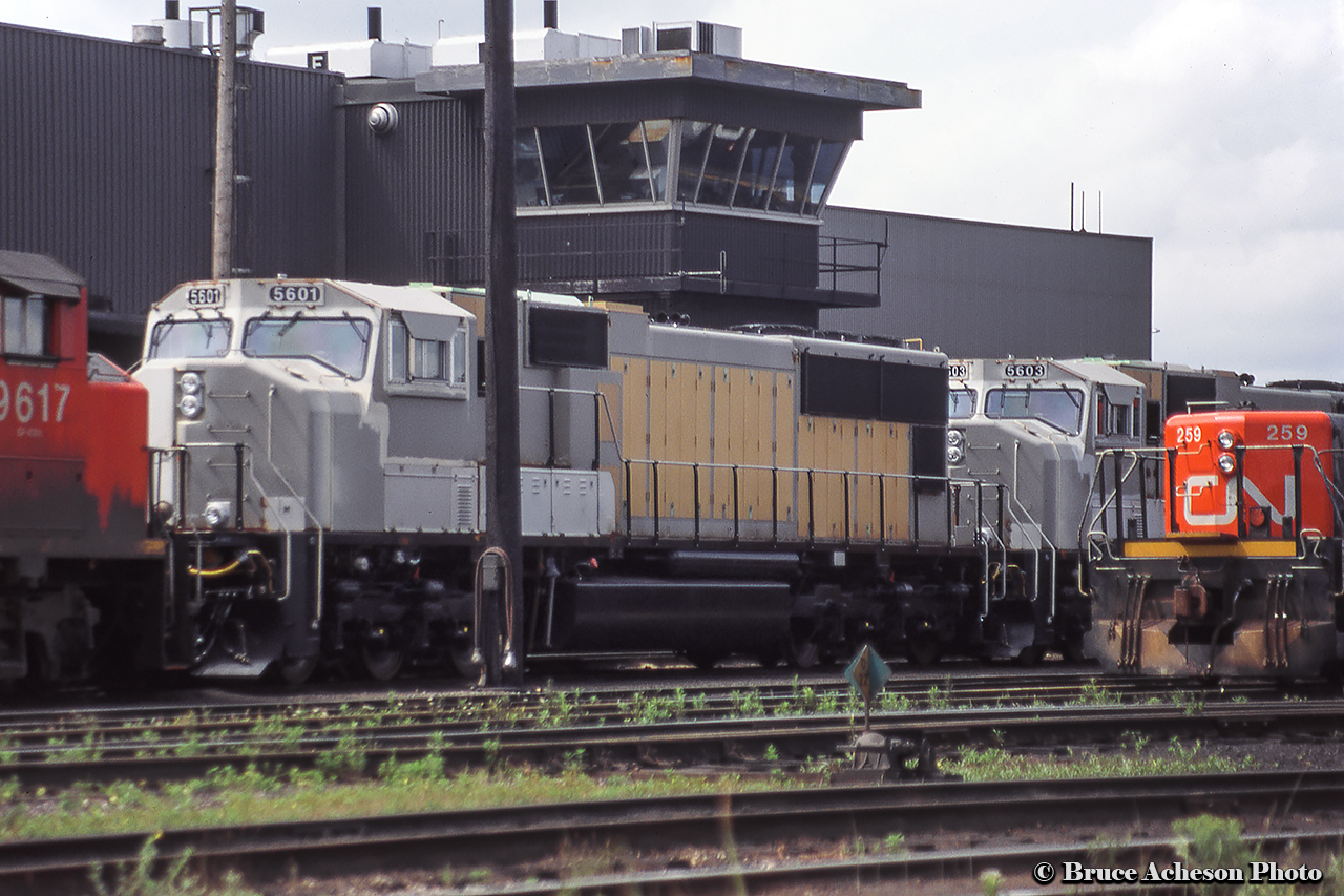 A scene on the Mac Yard power tracks finds GP40-2LW 9617 along with new SD70Is 5601, 5603 in primer and slug 259.  Three of the 4 units remain on the roster.  Slug 259, formerly CN 4609, originally NAR 211.  9617 would be off the CN roster the following year, sold in 1996 to HELM for use by KCS as 4715, later rebuilt to a GP40-3 and numbered KCS 2913.  It remains in service as of 2021.