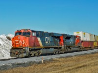 CN 2238 and 8919 pass the remains of a snow drift as they approach Wainwright with a west bound intermodal.