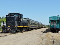 The Alberta Prairie Excursion train, headed by GMD-1m APXX 1118 sits on the siding at Stettler prior to rolling into the station to board the passengers.