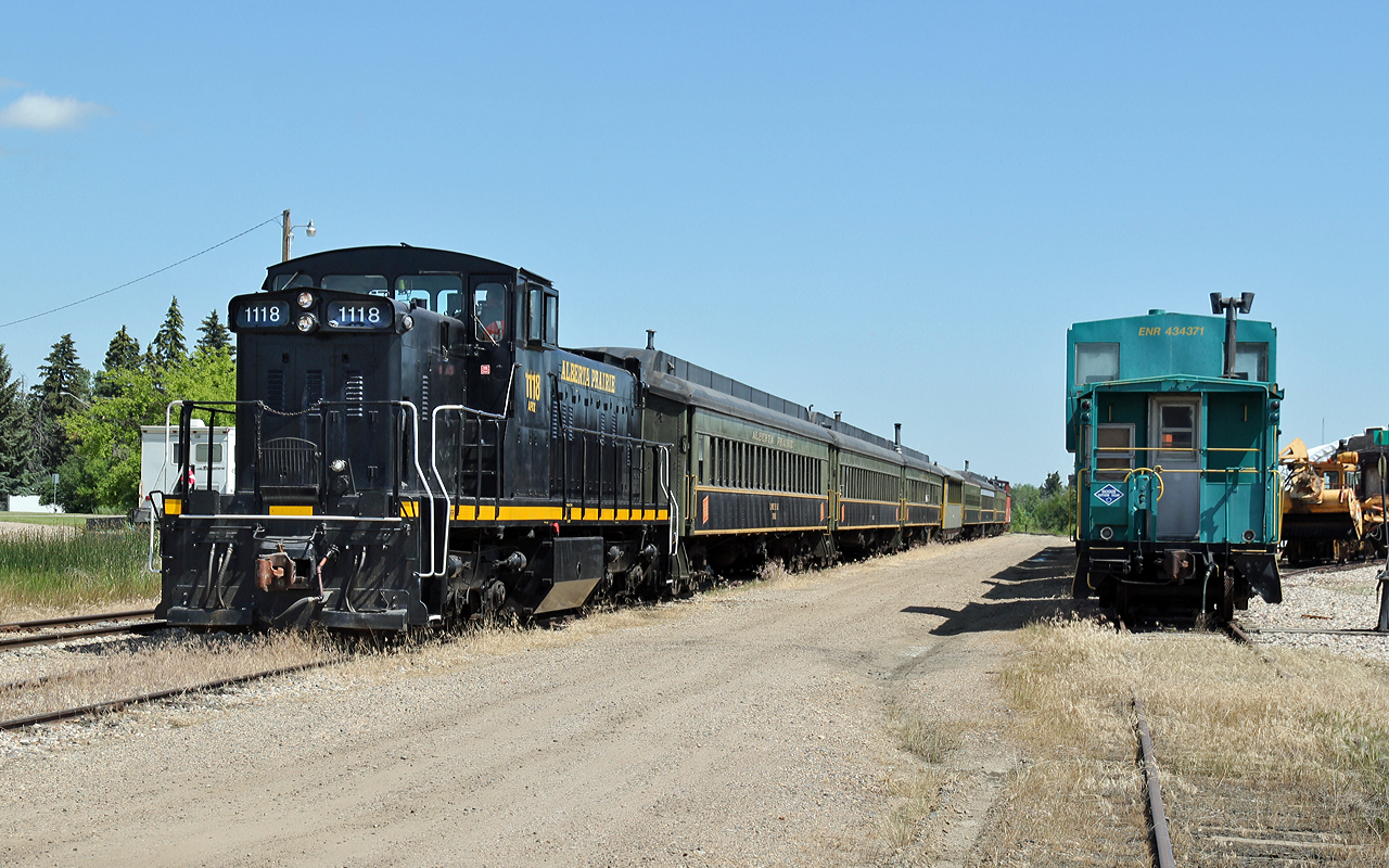 The Alberta Prairie Excursion train, headed by GMD-1m APXX 1118 sits on the siding at Stettler prior to rolling into the station to board the passengers.