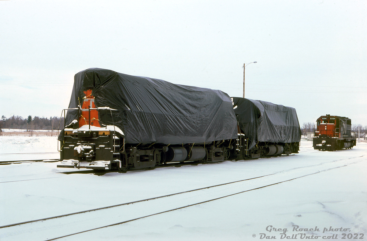 Two of CN's 3200-series MLW C424's (exact numbers unknown) sit tarped and stored out of service at CN's MacMillan Yard, near CN SD40 5064. Apparently 10 units were stored at MacMillan Yard, and 4 in Montreal, but no reason was noted on the slide (traffic downturn maybe?). Today, special large tarps for diesel locomotives stored out of service would be a frivolous extra expense at best.

Greg Roach photo, Dan Dell'Unto collection slide.