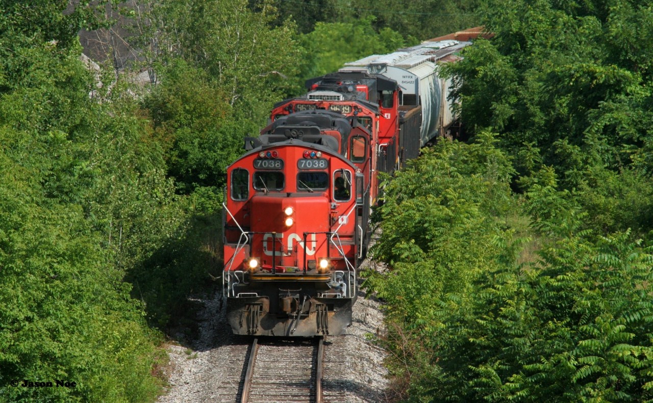 CN L568 with CN 7038, 4130, 9639 and 9449 are approaching the Stirling Avenue overpass in Kitchener as they return from the interchange with Canadian Pacific on the Huron Park Spur during a summer afternoon.