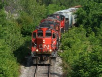 CN L568 with CN 7038, 4130, 9639 and 9449 are approaching the Stirling Avenue overpass in Kitchener as they return from the interchange with Canadian Pacific on the Huron Park Spur during a summer afternoon. 

