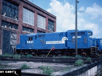 Conrail Canada Division GP7's 5822 and 5821 catch some sun behind the St Thomas diesel shop during summer 1982. 
