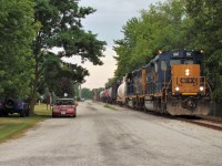 CSX 6547 and 6505 lead a 23 car local along Pulteney St. in Mooretown on their way back to Sarnia after switching Forge Hydrocarbons in Sombra and Lambton Generating in Courtright. The large Generating Station at Courtright is being dismantled and scrap is being shipped out by rail. CSX switches the place about 2-4 times a month and are currently running there Sunday afternoons.