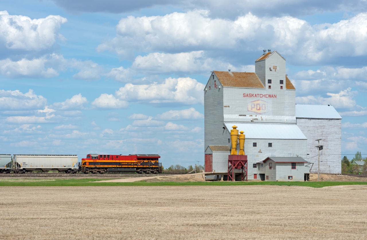 A sign of the changing times...  KCS ET44AC 5018 is the rear DPU on a loaded CP grain train passing the old Pool elevator at Lang Saskatchewan.