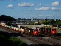 CN 121 at left is passing CN 321, which is stopped and waiting for an eastbound VIA to pass. CN 121 will be held out of Taschereau Yard, as CN 123 ahead is waiting to get into the yard (it will be able to enter once CN 377 leaves).