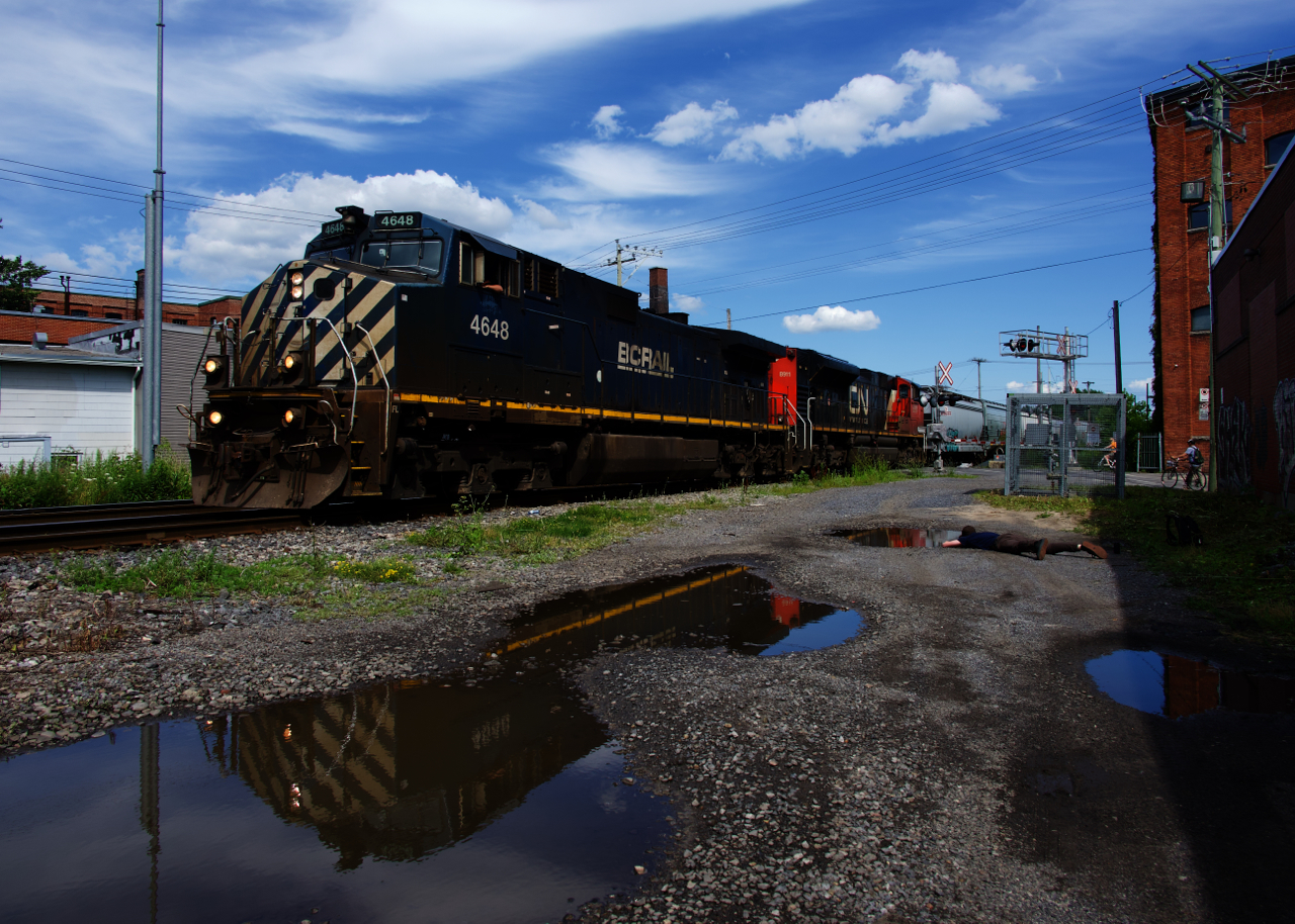 BCOL 4648 is leading CN 527 as it backs up towards Pointe St-Charles Yard. At right another railfan gets a low angle view of the train.