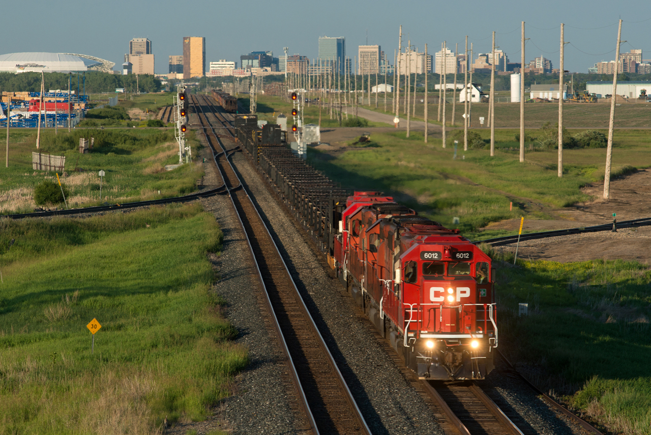 A quartet of CP EMDs lead a CWR train toward the setting sun and past the controlled location named "Foot" on the west side of Regina.