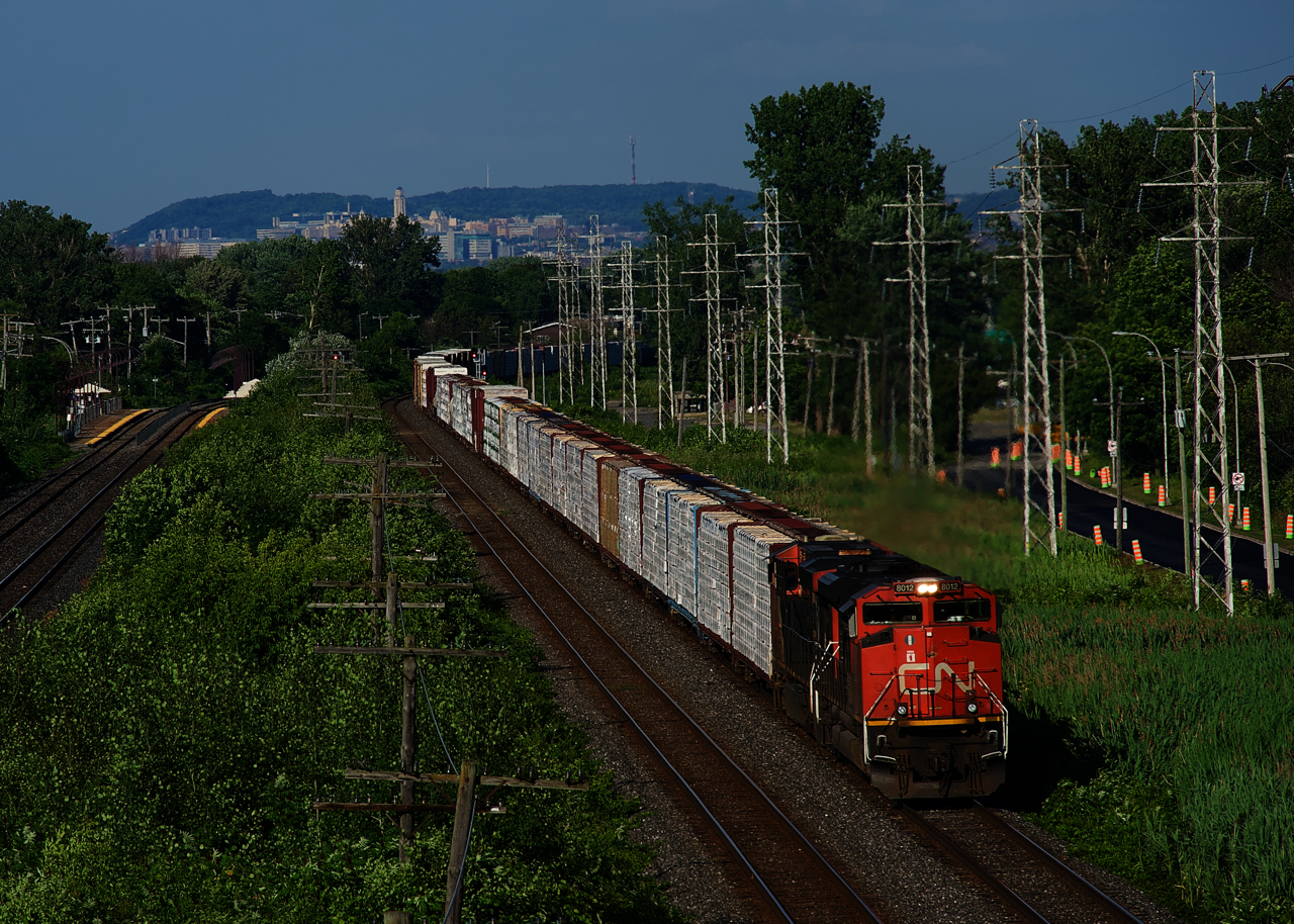A 128-car CN X377 rounds a curve with a lot of lumber up front and CN 8012 & CN 2230 for power.