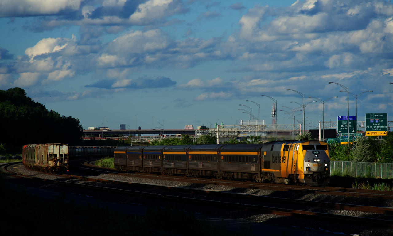 VIA 669 with VIA 909 and six stainless steel cars has just passed a parked potash train (CN B730).