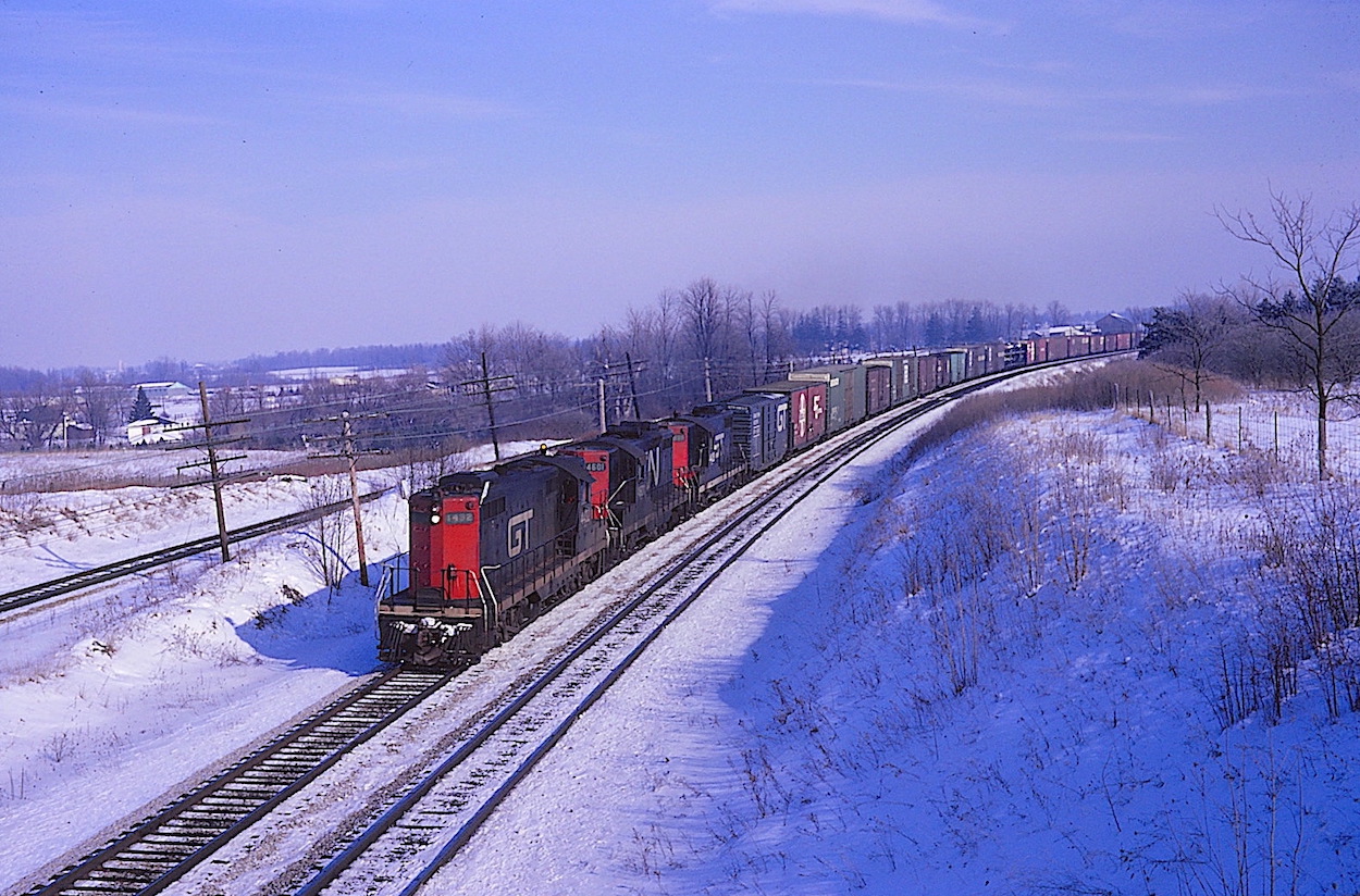 A trio of GTW and CN geeps charge west with a mixed manifest near Denfield Road on the outskirts of  London, Ontario. The leader in this Kodak moment from the past is GTW #4432 (ex-GTW #1756).