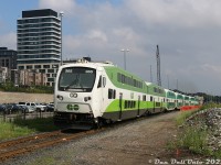 Intensification is the name of the game for a lot of development in the GTA, and the new townhouses and condos/apartments under construction by Maple GO Station (on lands that were once quarries and gravel pits) are just one example. GO Transit cab car 365 does the usual 14L for the crossing as it departs Maple with northbound train #6825 from Toronto to Barrie, after unloading passengers at the old Grand Trunk station building (the shorter L6 consists stop closer to the station for the accessible car).
