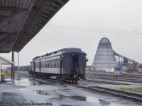 <b>Almost the end, Part 2.</b>  After moving about the yard <a href=http://www.railpictures.ca/?attachment_id=48327>(see part one here),</a> mixed train 273 is now on the station track, and with the step box down, waits for passengers to board combine 7210.  Note the blue and gray shack at right which appears to be a scale house.<br><br>Situated along the original National Transcontinental Railway line, built through the area in 1913, Hearst lies at the west end of the Kapuskasing Subdivision (Coachrane, mile 0 - Hearst, mile 129.1) and the east end of the Pagwa Subdivision (Hearst, mile 0 - Nakina, mile 144.1). Situated away from CN's mainline, the Kapuskasing and Pagwa Subs saw few upgrades and deferred maintenance over the years resulting in equipment restrictions on both lines. The Pagwa Sub specifically was still largely comprised of rails smaller than 80lb resulting in SW1200RS units being the heaviest permitted on the line, giving us the interesting scene here.<br><br>Officially mixed trains 272/273 in the timetable, and operated by VIA Rail by the time of this photo, the trains no longer operated with freight in the consist as only one customer remained on the 144.1 mile line, Arthur Lecours Lumber Mill at Calstock (mile 22.7). It would typically be serviced by a job from Hearst. There is not long left for trains 272/273. With virtually no traffic on the line, attributed to the mainline further south, and deferred maintenance restricting load capacity, CN's request to abandon the Pagwa Sub west of Calstock would be approved, with the rails lifted in 1986. In August 1993, the Kapuskasing Sub and Pagwa Sub to Lecour's mill would be sold to the Ontario Northland Railway. Information per Chris van der Heide and his website, <a href=http://vanderheide.ca/blog/2015/12/04/cn-operations-at-hearst/>Algoma Central in HO Scale (more info on Hearst here).</a><br><br>By this time, the original <a href=http://www.railpictures.ca/?attachment_id=23918>Hearst station</a> had been retired but still stood with it's smaller replacement a few feet to the west (as seen in Arnold's linked image).<br><br>CN 1392, built by GMD in 1960, would meet an untimely end on November 9, 1997 while assigned to the to the Shawinigan Falls Terminal Railway after being destroyed by a landslide. It would be chopped up onsite.<br><br>More 1392<br><a href=http://www.railpictures.ca/?attachment_id=34919>Pups through Bayview,</a> Dave Burroughs, 1967<br><a href=http://www.railpictures.ca/?attachment_id=47516>Departing Toronto Yard,</a> First954, 1969<br><br>Combine 7210, a Canadian Car & Foundry product of 1919, was assigned to mixed 272/273 for at least a decade before being reassigned to the "Muskeg Mixed" in Alberta:<br><a href=http://www.railpictures.ca/?attachment_id=48331>At Hearst 1976 with journal boxes,</a> by Paul O'Shell<br><a href=http://www.railpictures.ca/?attachment_id=46705>At Egremont, AB, July 1986 in VIA Rail colours,</a> by Seth B.<br><br><i>Don Jilson Photo, Jacob Patterson Collection slide.</i>