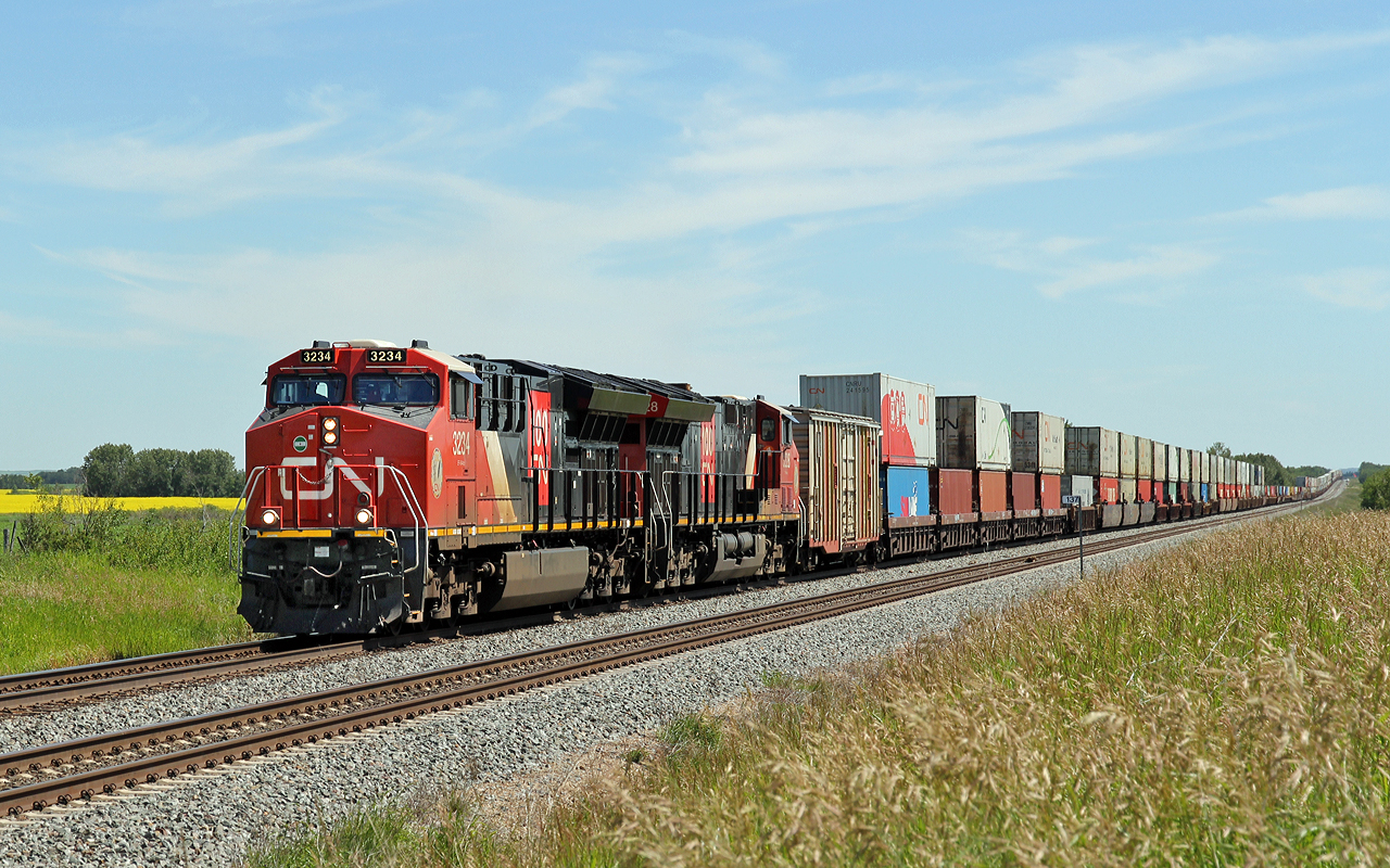 A pair of ET44Acs, CN 3234 and CN 3228 approach Wainwright on the double track at Greenshields