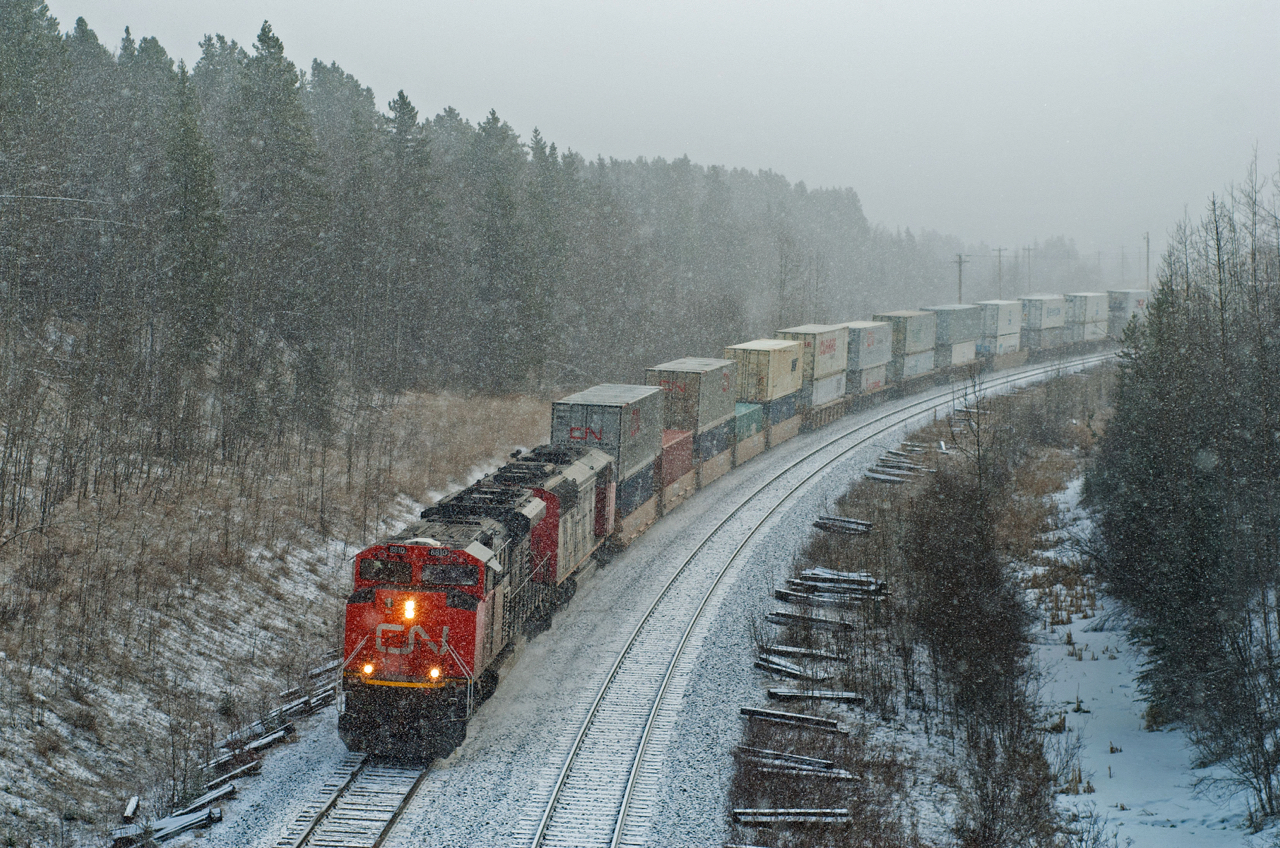 A late April Alberta snow storm partially obscures CN 111 as it rounds the bend into Obed on the Edson Sub.