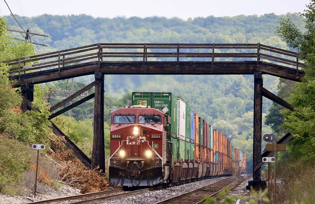It’s one of those signature Southern Ontario shots. Chances are if you are a railfan in Ontario you have taken at least one photo here. Granted the motive power this day could have been more exciting, especially considering that the Hapag Lloyd unit was unfortunately in DPU status and visible in the distance and not on the head end. The sounds here are just as dramatic as the scenery as the heat wave blur the Niagara escarpment looming in the background as the train ducks under the old wooden farm bridge. It’s a steep climb to Guelph junction from here and the motive power is being put to the test. It’s not often I get to catch this train as it’s typically a night or early morning train so this was a nice catch.