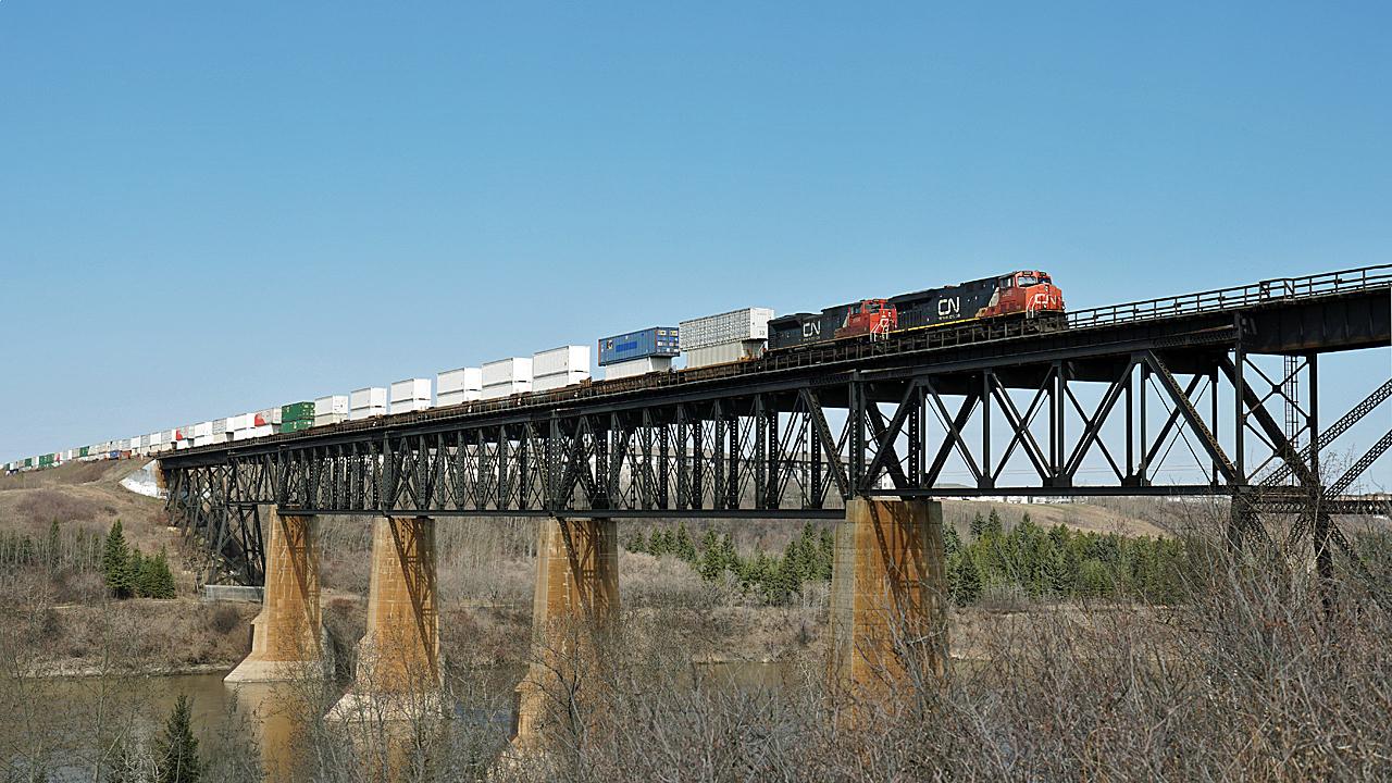 ES44DC CN 2259 and SD70M-2 CN 8964 lead an eastbound intermodal over the North Saskatchewan River at Clover Bar.