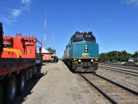 While VIA 692 lead by VIA 6448 sitting on the bolted rail mainline at Canora, SK commands the center of attention in this photo, there is so much more going on all around the shot. Off to the right of the locomotive are piles of new track material (spikes, anchors, tie plates) suggesting some major track work is in the works. To the left is a 2000 model year Freightliner 114 SD CN hi-rail boom truck (CN 270195) with tie grapple, a retired CN transfer van (CN 76659) on display at the historic 1904 built Canora station, a green flag signaling the end of a slow order on the line, a couple of communication towers with antennas pointing skyward, a few passengers milling about, a VIA on board service person manning the step box near the end of the train, and in the distance, sitting quietly in the yard waiting its next assignment is CN 5626. This 118 year old station got its name from a shortened Canadian Northern Railway .... CaNoRa. The building is now a visitor information center, museum, and VIA Rail station stop. Another beauty day for train travel and taking photos. ????