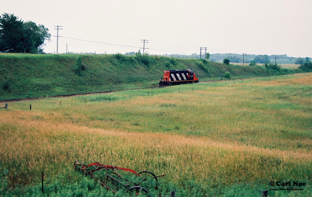 So quietly and almost unnoticed, CN GP9RM 4119 is pictured heading eastbound solo through the countryside at Newtonville, Ontario on the Kingston Subdivision.
