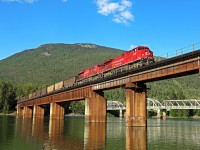 Starting out over the CP's Shuswap Sub in fine evening light, CP 8160 and 8905 have a westbound coal train in tow as they cross the Columbia River at Revelstoke BC. Helpers include mid-train dpu 9889 and rear end dpu 9823.